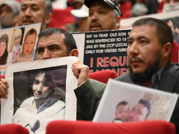 Mitglieder der uigurischen Gemeinde zeigen Fotos ihrer gefangen genommenen Verwandten in China bei einer Pressekonferenz in Istanbul.