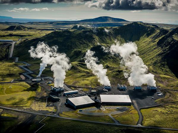 Dampf steigt vom Thermalkarftwerk Hellisheidi auf. Auf dem Geläde seht eine Anlage der Firma Climeworks, die der Luft CO2 entziehen kann. 