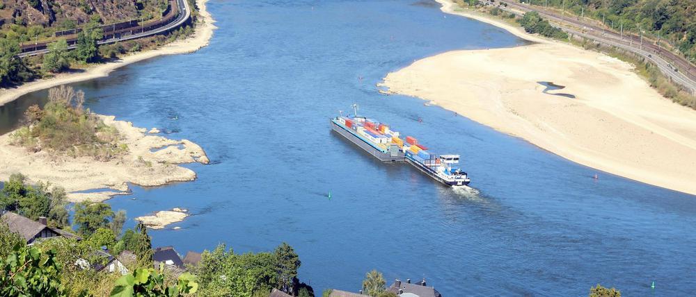 Ein Frachtschiff fährt auf dem Rhein an einer Sandbank vorbei (Symbolbild).