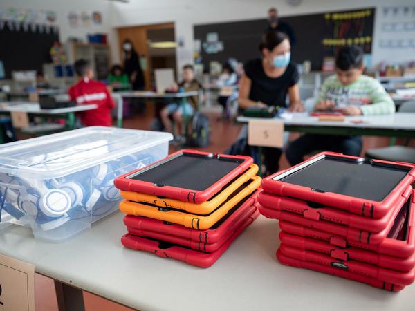 Tablets liegen in einer Grundschule vor einer Klasse.