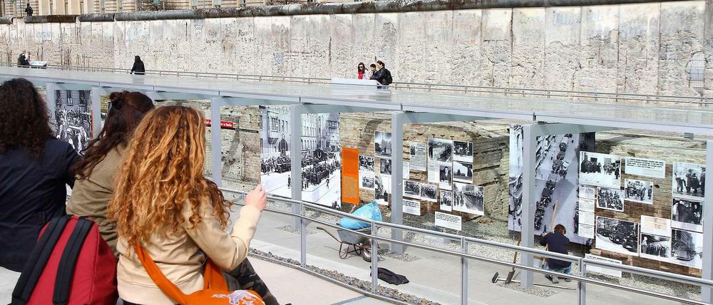 Schülerinnen sitzen in der Gedenkstätte Topographie des Terrors auf einer Mauerkante.