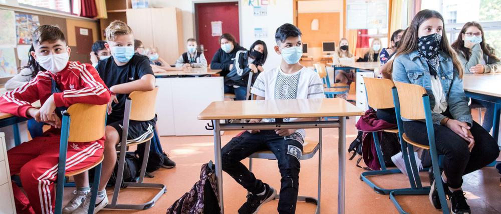 Schüler einer 7. Klasse einer Hamburger Stadtteilschule sitzen zu Beginn des Unterrichts mit Mund-Nasen-Bedeckungen im Klassenraum
