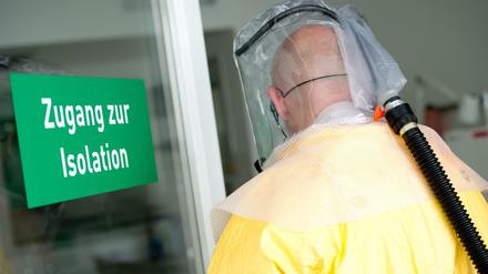 Ein Mann in Schutzausrüstung betritt bei einem Pressetermin eine Sonderisolierstation in einem Münchner Klinikum.