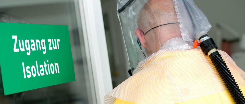 Ein Mann in Schutzausrüstung betritt bei einem Pressetermin eine Sonderisolierstation in einem Münchner Klinikum.