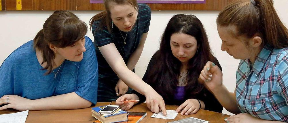 Vier junge Frauen sitzen beim Sprachunterricht an einem Tisch.