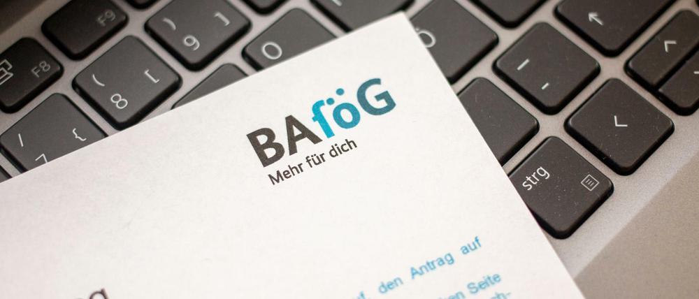 Ein Antrag auf Ausbildungsförderung (Bafög) liegt auf der Tastatur eines Laptopcomputers.