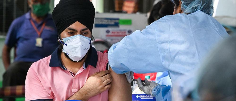 Ein Mann in Neu Delhi wird geimpft