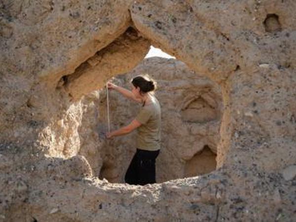 Eine Archäologin bei der Bauaufnahme in einer Ruine.