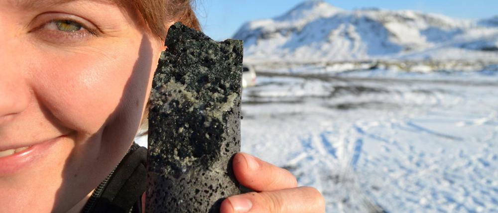 Da steckt's drin. Ko-Autorin Sandra Snaebjornsdottir zeigt einen Bohrkern aus dem Untergrund. Die hellen Minerale sind Karbonate, die offenbar bei der Reaktion von Kohlendioxid mit dem Gestein entstanden sind. 
