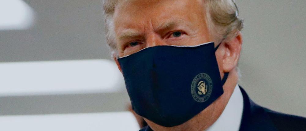 Donald Trump Präsident der USA, trägt einen Stoff-Mundschutz, auf dem das Präsidenten-Siegel abgebildet ist